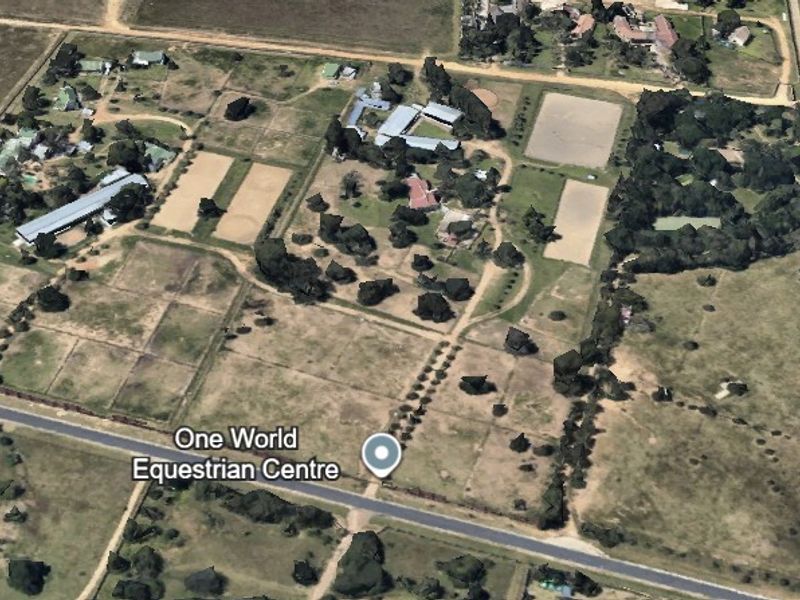 Aerial view of the One World Equestrian Centre property, showcasing multiple arenas, stable blocks, paddocks, and surrounding land.