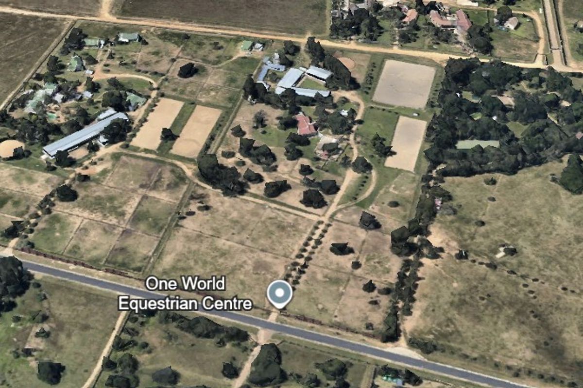 Aerial view of the One World Equestrian Centre property, showcasing multiple arenas, stable blocks, paddocks, and surrounding land.