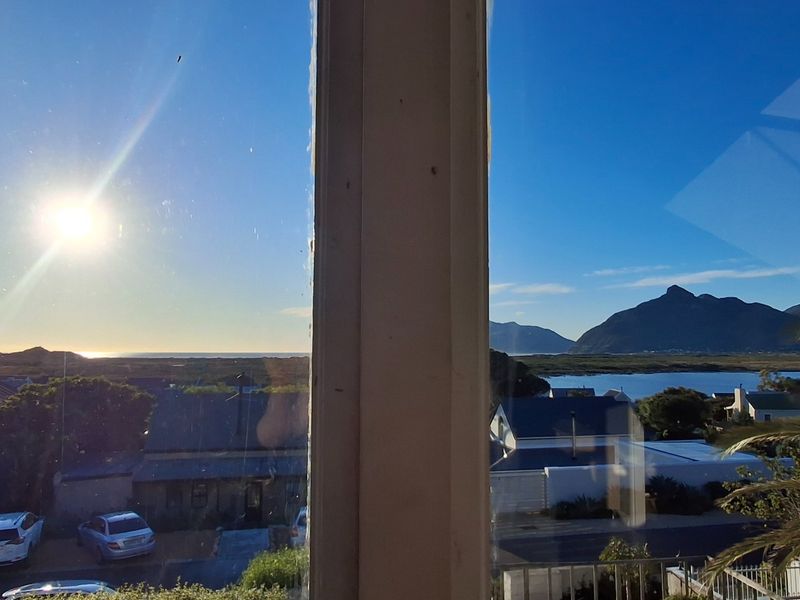 A scenic view of the surrounding landscape, mountains, and water, captured through a window.