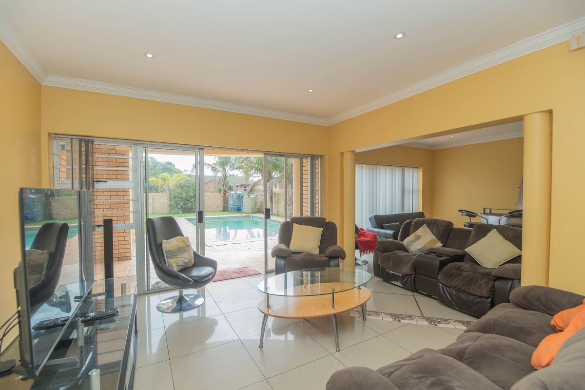 Spacious living area featuring large sliding glass doors that provide direct access to the outdoor pool area and natural light.