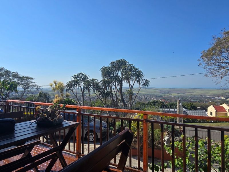 Elevated wooden deck balcony featuring a timber balustrade and expansive panoramic views of the surrounding landscape.