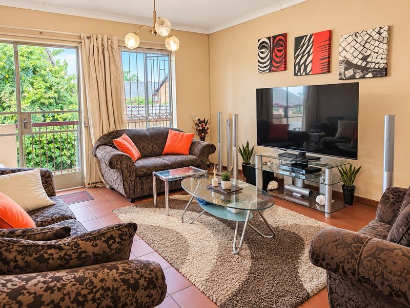 A comfortable living room featuring tiled flooring and a sliding glass door that provides access to an outdoor area.