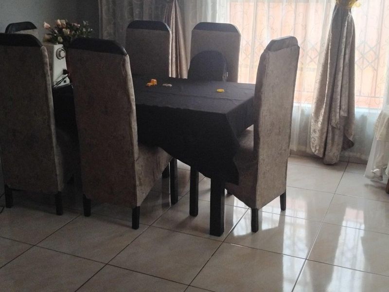 A dining area featuring tiled flooring and access to a sliding door, providing a functional space for meals.