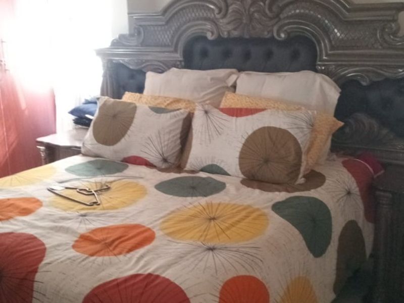 A bedroom featuring tiled flooring and a decorative ceiling finish, providing a functional space with potential for modern updates.