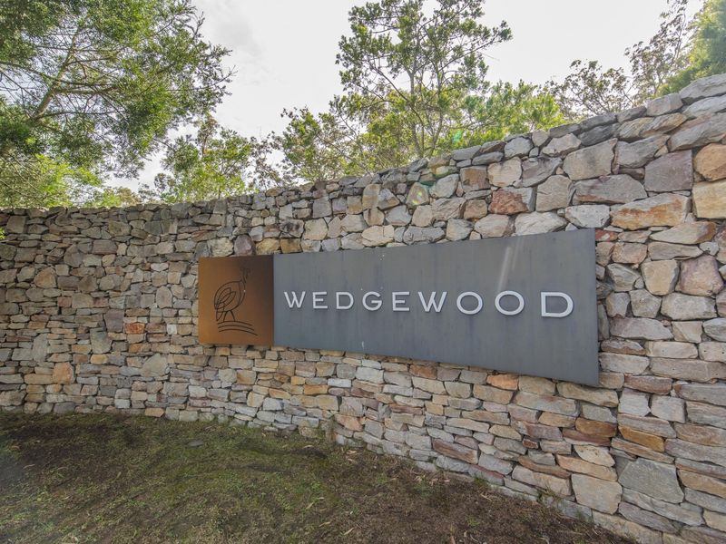 Entrance signage for Wedgewood estate featuring a decorative stone boundary wall and professional branding.