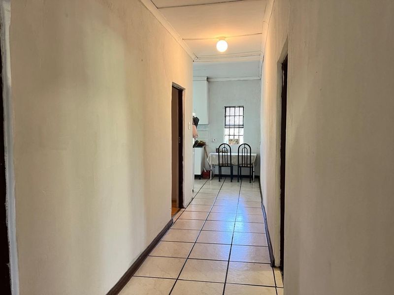 A functional hallway featuring tiled flooring and neutral wall finishes, providing direct access to adjacent rooms within the property.