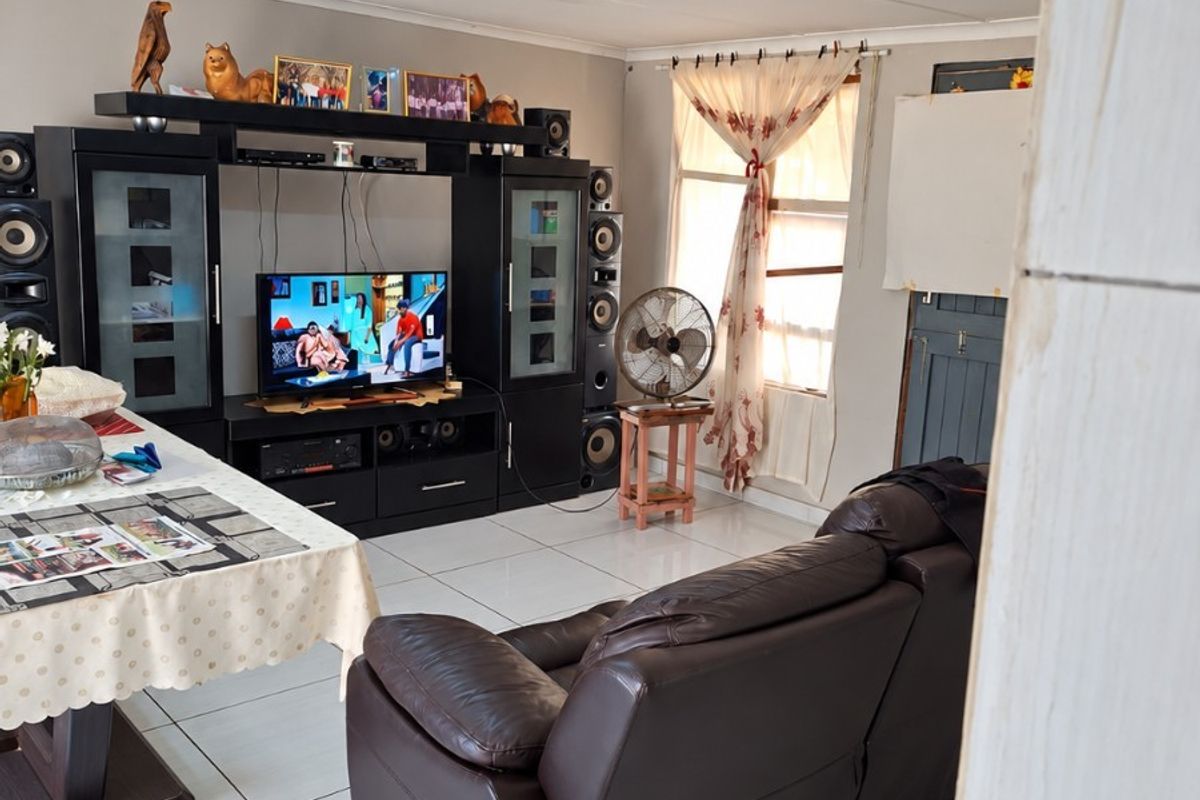 A living room featuring tiled flooring and a standard ceiling finish, providing a functional space for relaxation and entertainment.