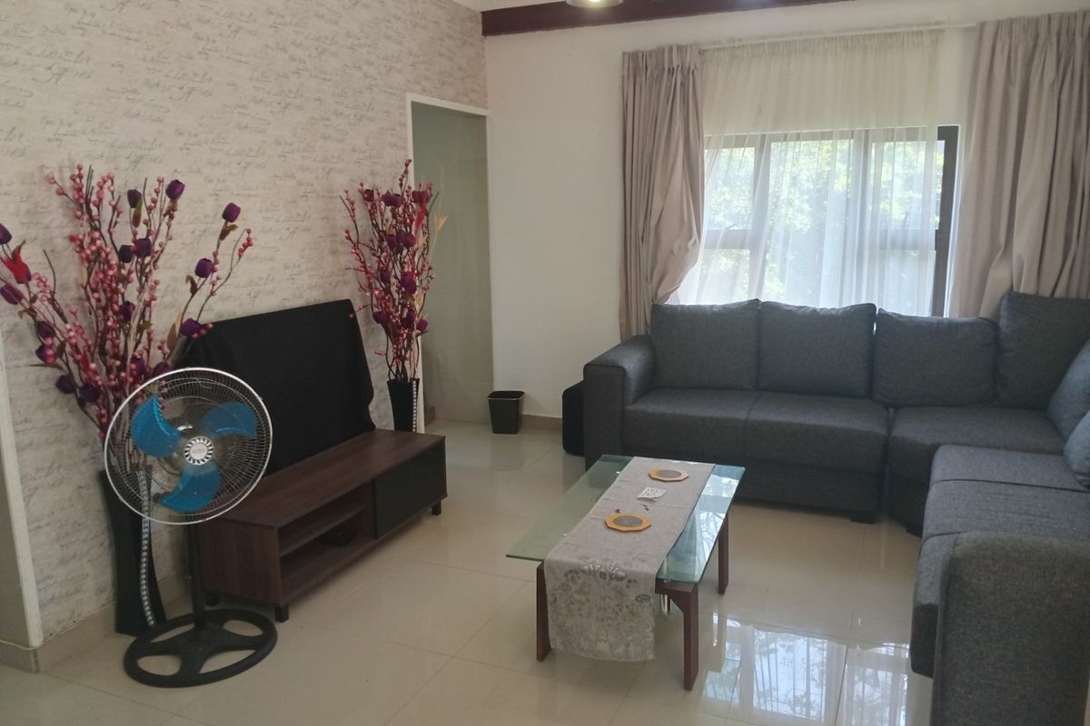 A comfortable living room featuring tiled flooring, neutral wall finishes, and large windows that allow for natural light.