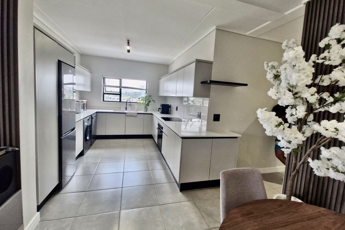 Modern kitchen featuring sleek built-in cabinetry, stone countertops, integrated appliances, and large format floor tiles in a clean, contemporary layout.