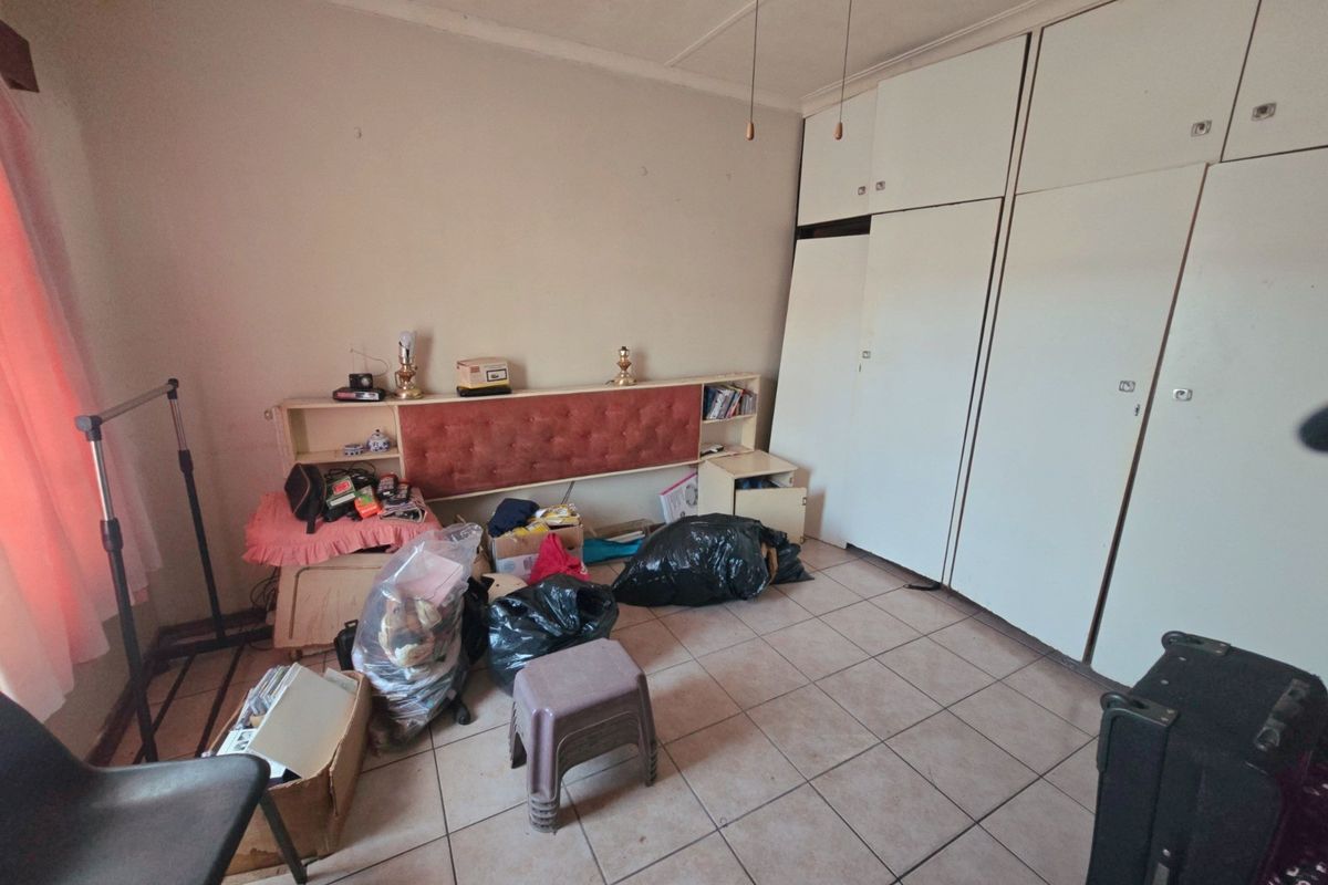 Bedroom featuring tiled flooring, a ceiling fan, and extensive built-in cupboard storage space.