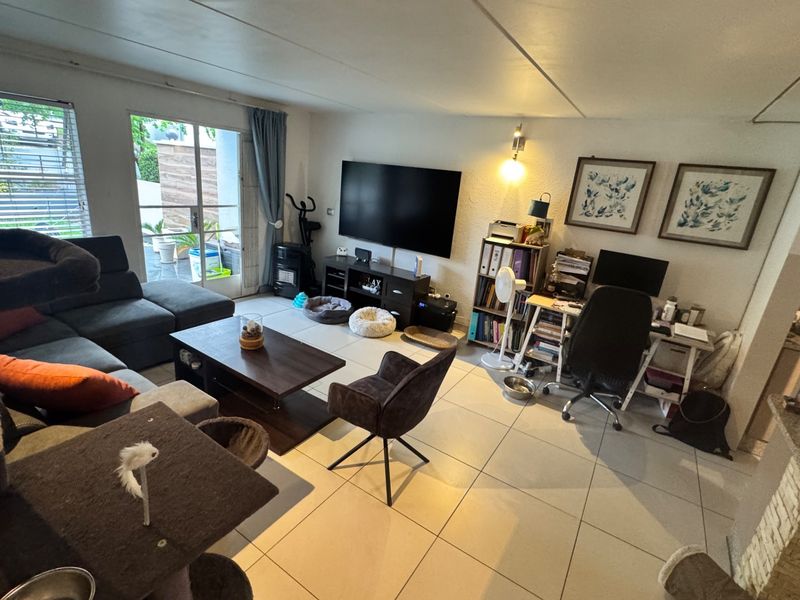 Spacious living room featuring large format floor tiles and a sliding glass door providing access to the outdoor area.