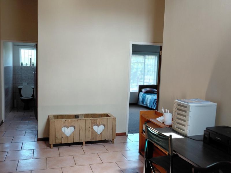 A functional hallway area featuring tiled flooring, providing access to adjacent rooms including a bathroom and bedroom.