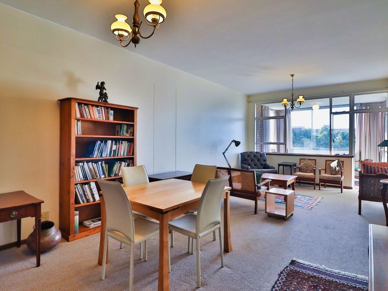 Spacious open-plan living and dining area featuring large windows that provide ample natural light and a view of the surrounding area.