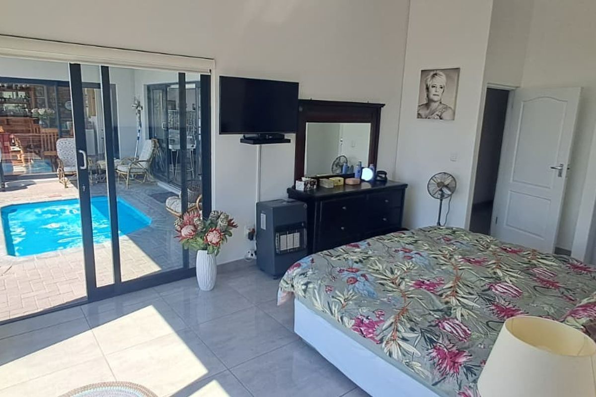 Spacious bedroom featuring large sliding glass doors that provide direct access to the outdoor pool area and patio.