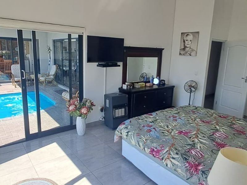 Spacious bedroom featuring large sliding glass doors that provide direct access to the outdoor pool area and patio.