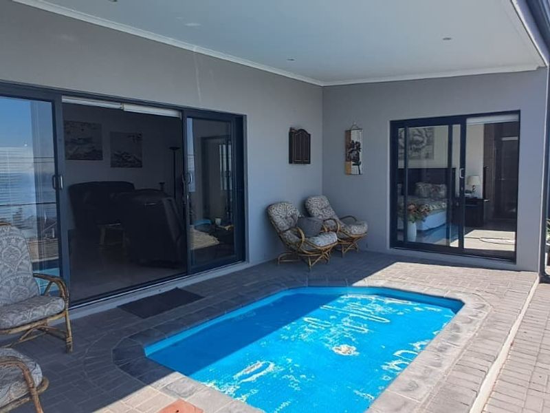 A covered patio area featuring a small plunge pool and direct access to the interior through large sliding glass doors.