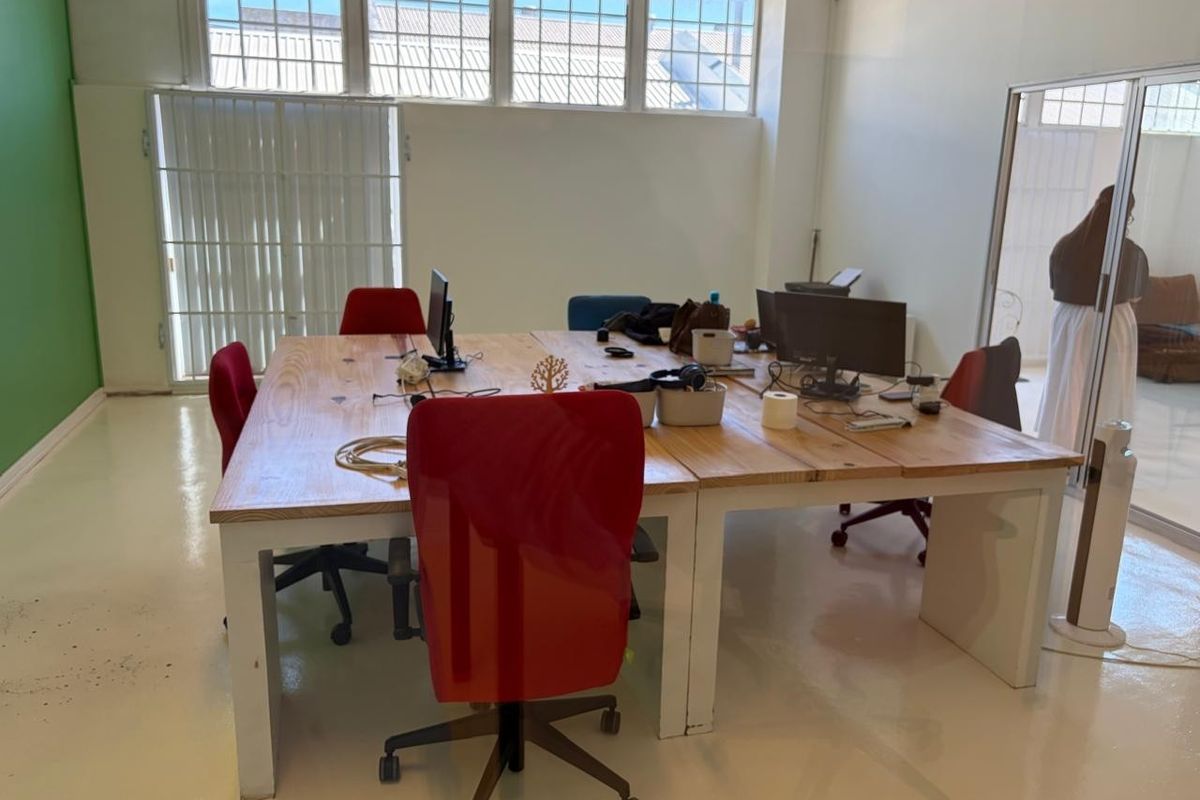 A bright, open-plan office space featuring high-level multi-pane windows, durable epoxy flooring, and a modern glass partition wall.