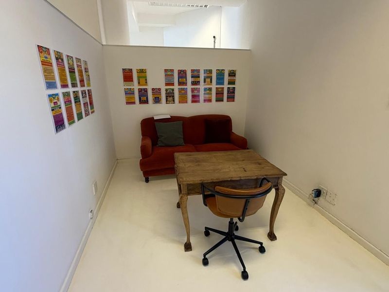 A compact office space featuring white painted walls, smooth flooring, and integrated electrical points, suitable for a private workspace or consultation room.