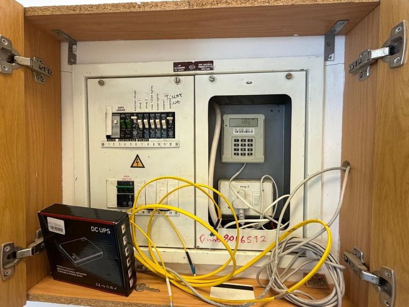 A utility cabinet housing the property's electrical distribution board and a prepaid electricity meter.