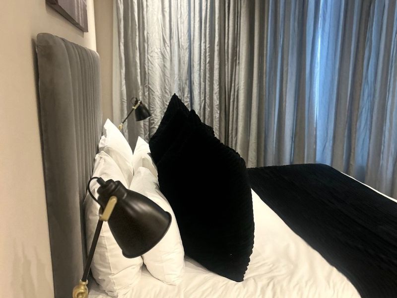 A well-appointed bedroom featuring recessed ceiling lighting and an integrated air conditioning unit, creating a comfortable and modern living space.