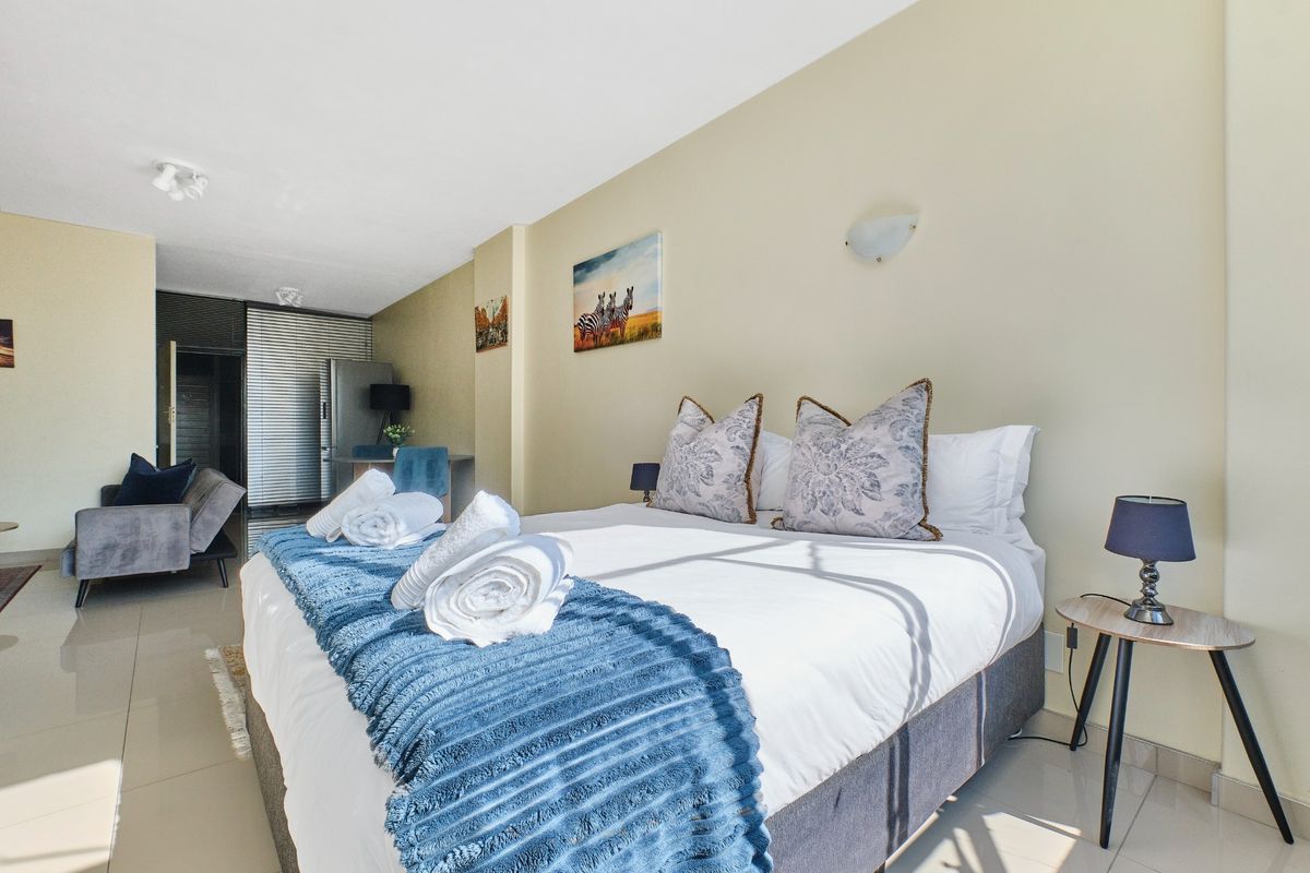 A well-lit bedroom featuring tiled flooring and neutral wall finishes, providing a comfortable and functional living space.