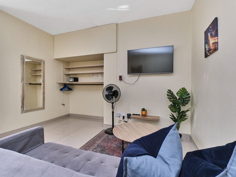 A living area featuring tiled flooring and built-in open shelving storage.