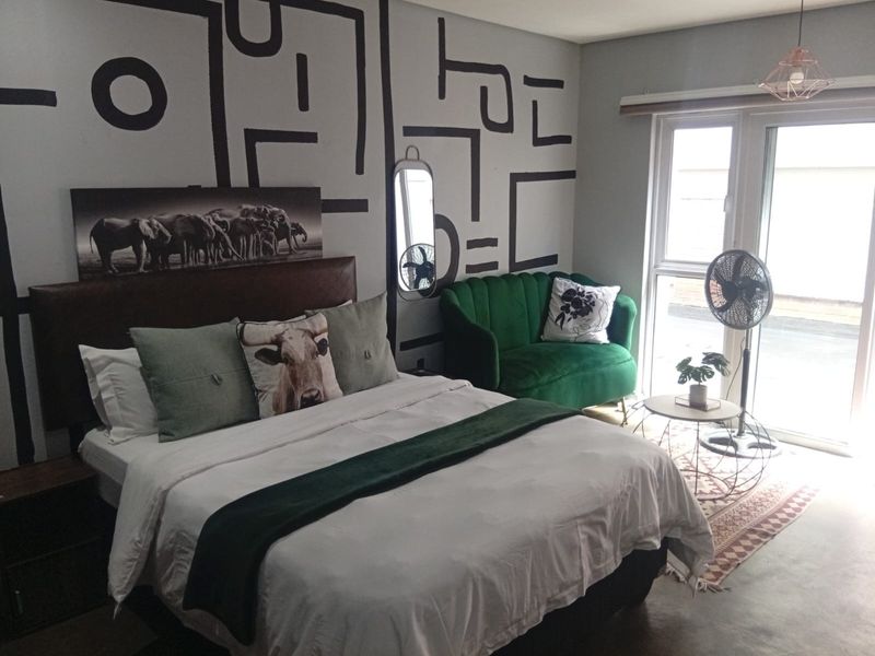 A bedroom featuring a sliding glass door providing natural light and a modern pendant light fixture.