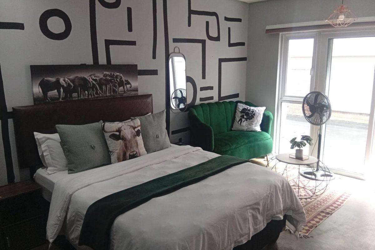 A bedroom featuring a sliding glass door providing natural light and a modern pendant light fixture.