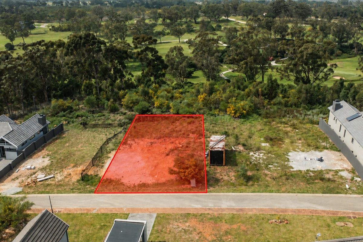 Aerial view of a vacant residential plot situated in a developed estate, bordering a golf course and adjacent to existing modern homes.