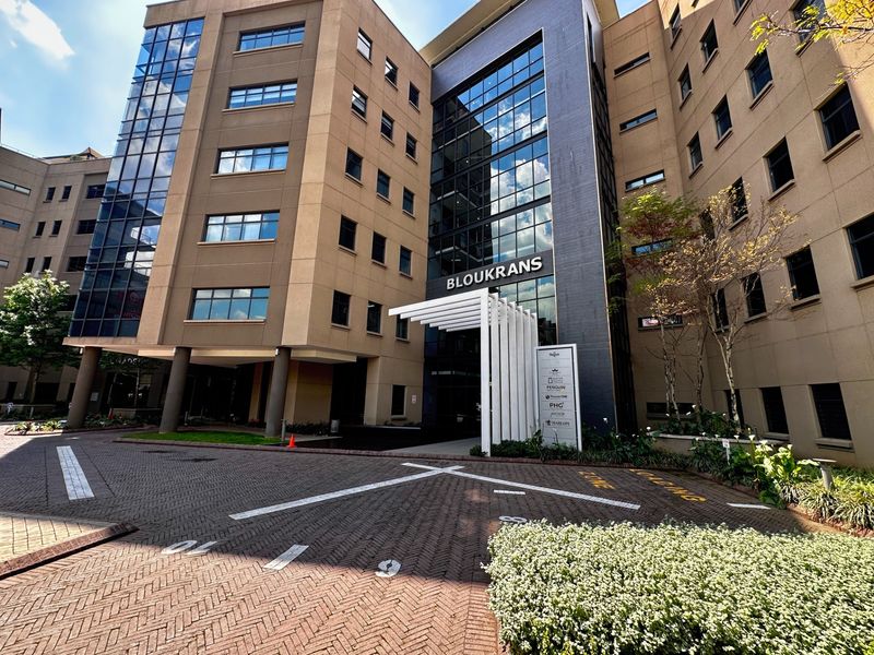 Front exterior view of the Bloukrans office building, featuring a modern glass facade, paved driveway, and a prominent entrance canopy.