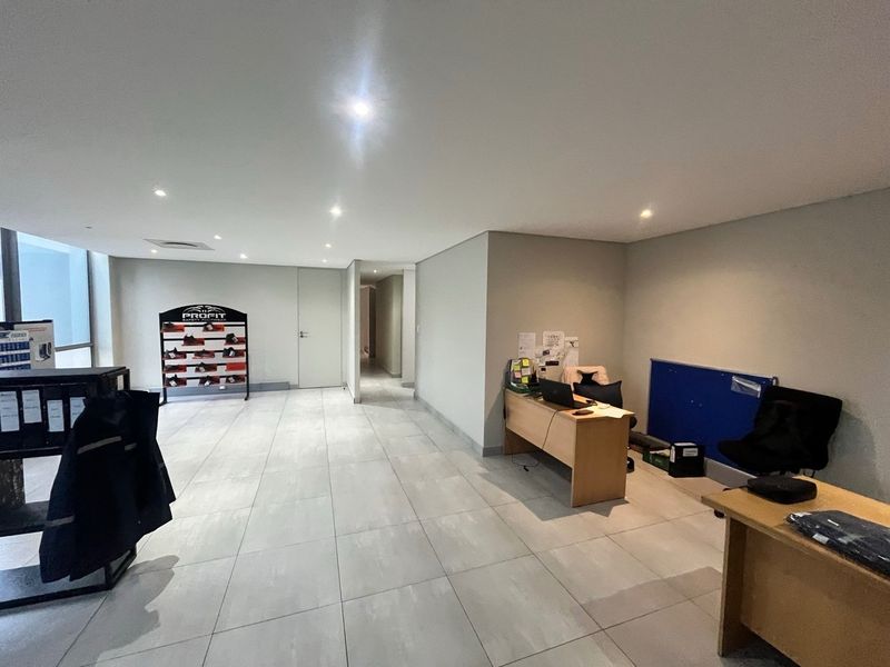A functional office space featuring neutral tiled flooring, recessed ceiling lighting, and a clean, open layout suitable for professional industrial operations.