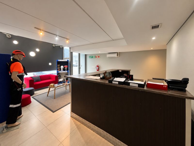 A professional industrial reception area featuring a built-in service counter, tiled flooring, and climate control, providing a welcoming entry point for the facility.