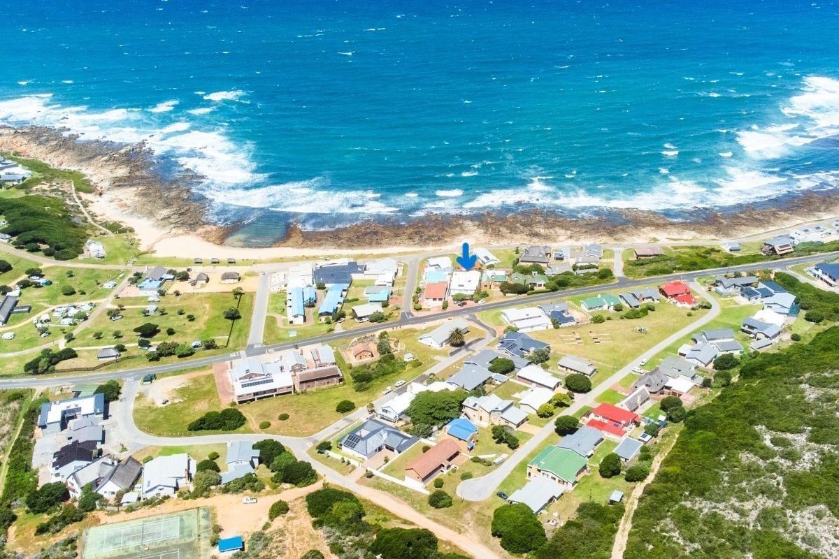 An aerial view of the coastal residential neighbourhood, highlighting the property's proximity to the ocean and local infrastructure.