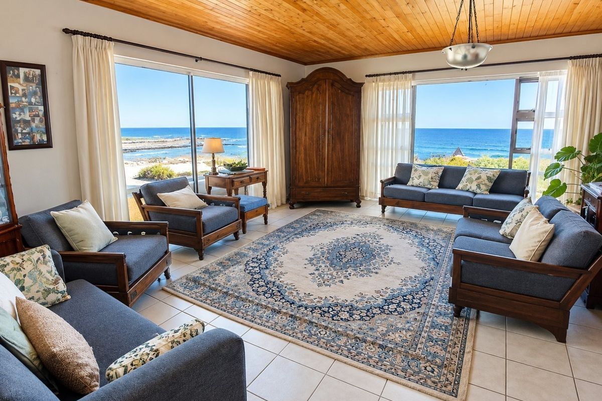 Spacious living room featuring a timber-clad ceiling, tiled floors, and expansive sliding glass doors offering panoramic ocean views.