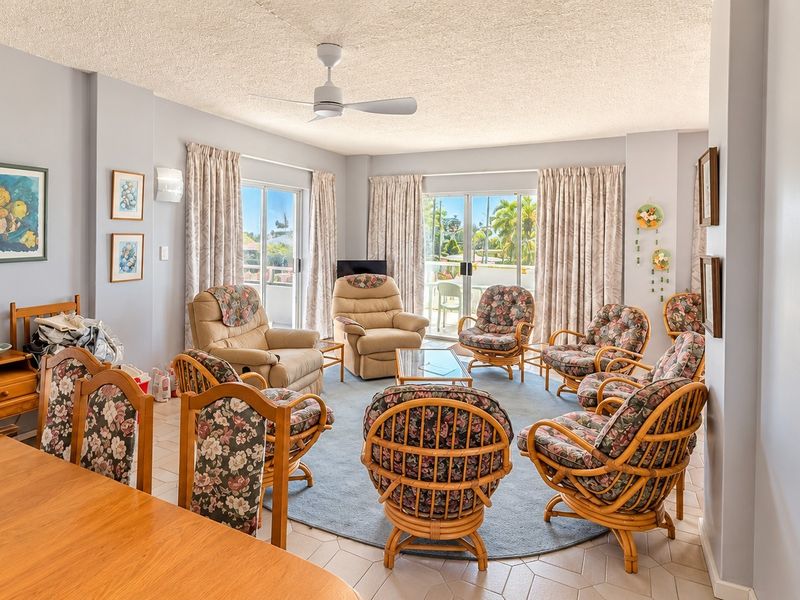 Spacious living area featuring tiled flooring, a ceiling fan, and large sliding glass doors that provide access to an outdoor balcony.