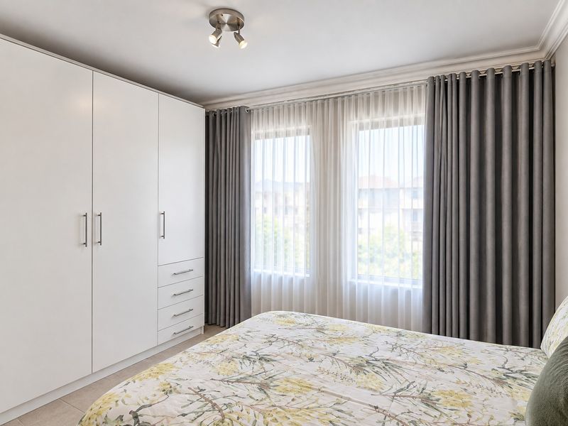 A well-maintained bedroom featuring a large built-in wardrobe, tiled flooring, and modern ceiling spotlighting with neutral window treatments.