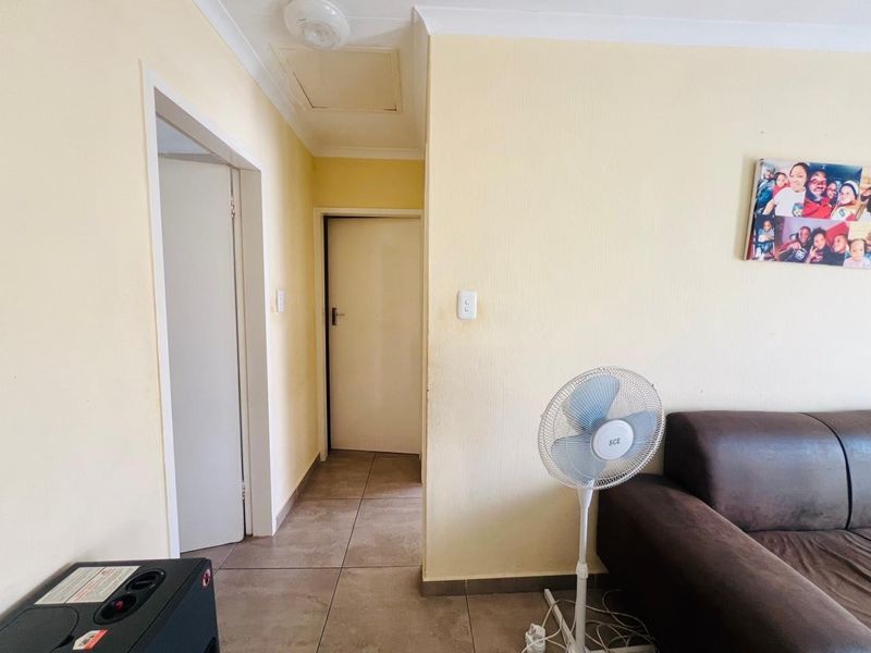 A functional hallway area featuring tiled flooring and standard internal doors, providing access to other rooms within the apartment.