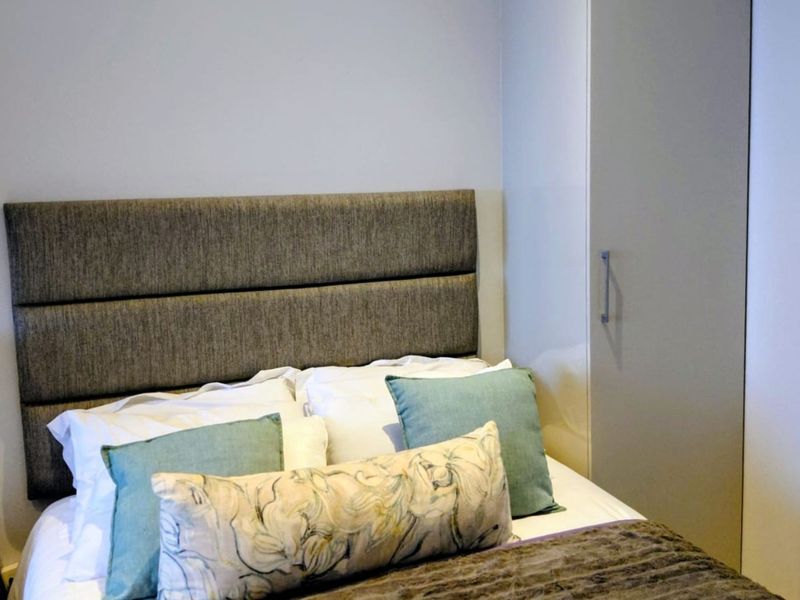 A well-maintained bedroom featuring a neutral color palette and a functional built-in wardrobe for efficient storage.