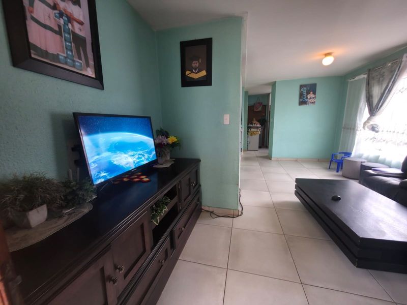 A living room area featuring light-colored ceramic floor tiles and painted walls, providing a functional and open living space.