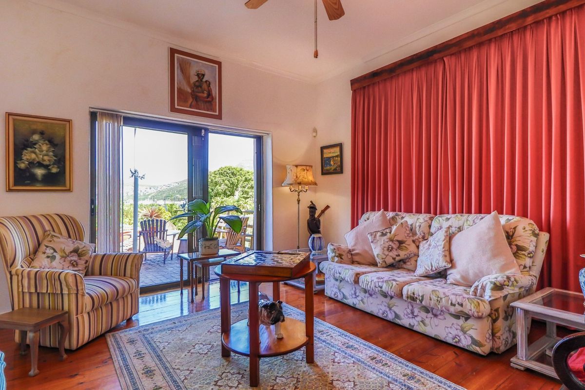 A cozy living room featuring polished hardwood flooring, a ceiling fan, and large sliding glass doors that provide access to an outdoor patio area.