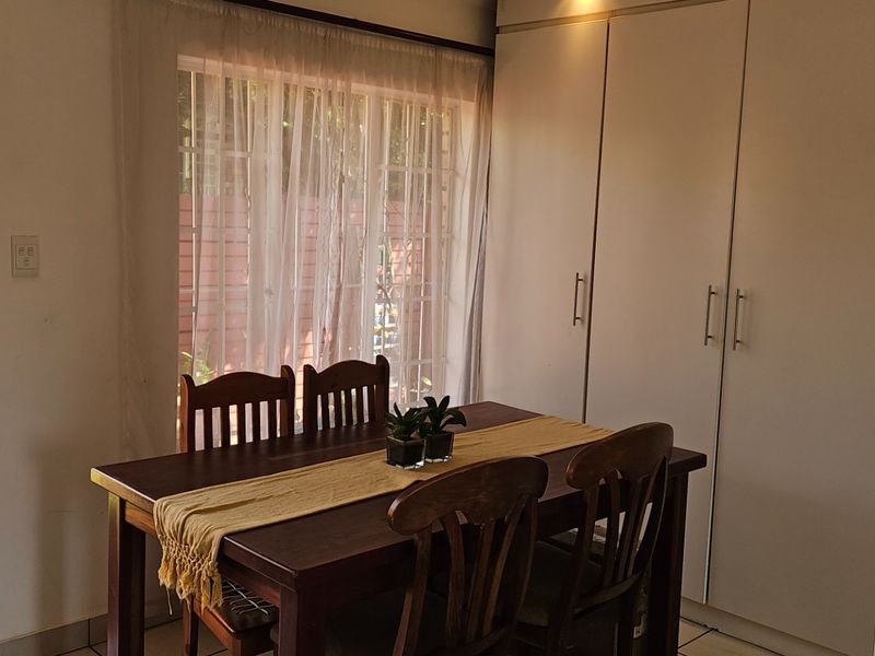 Dining area featuring built-in storage cupboards, tiled flooring, and direct access to an outdoor patio area through a sliding glass door.