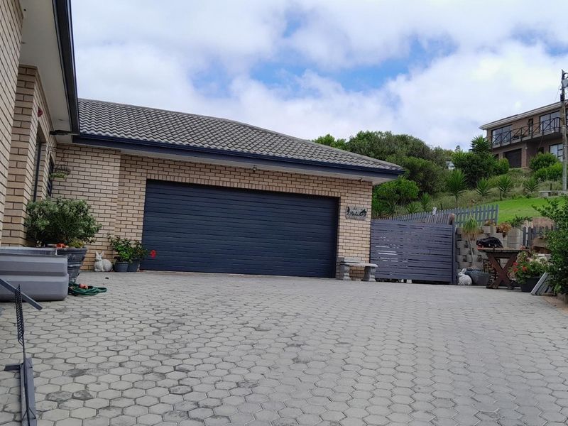 Front exterior view of the property featuring a brick facade, a paved driveway, and a secure garage.