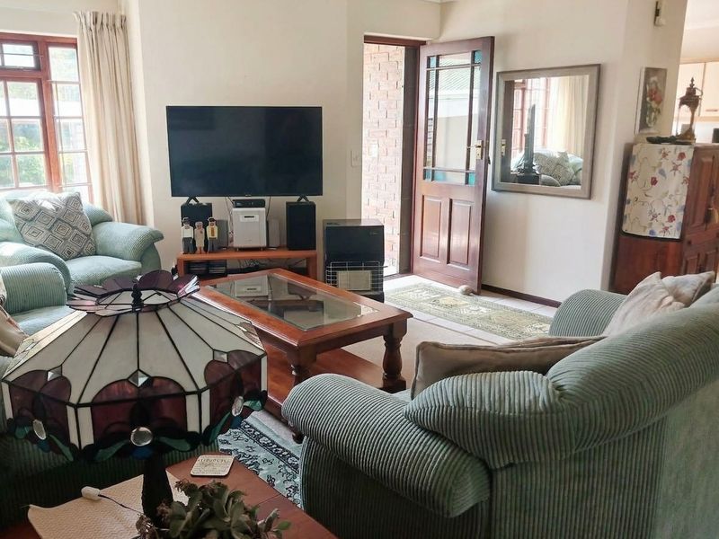 A comfortable living room featuring timber-framed windows and a classic timber entrance door, offering a warm and inviting atmosphere.