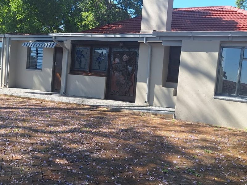 Rear view of the house featuring a tiled roof, brick paved area, and exterior wall finishes.