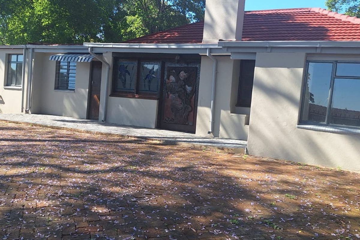 Rear view of the house featuring a tiled roof, brick paved area, and exterior wall finishes.