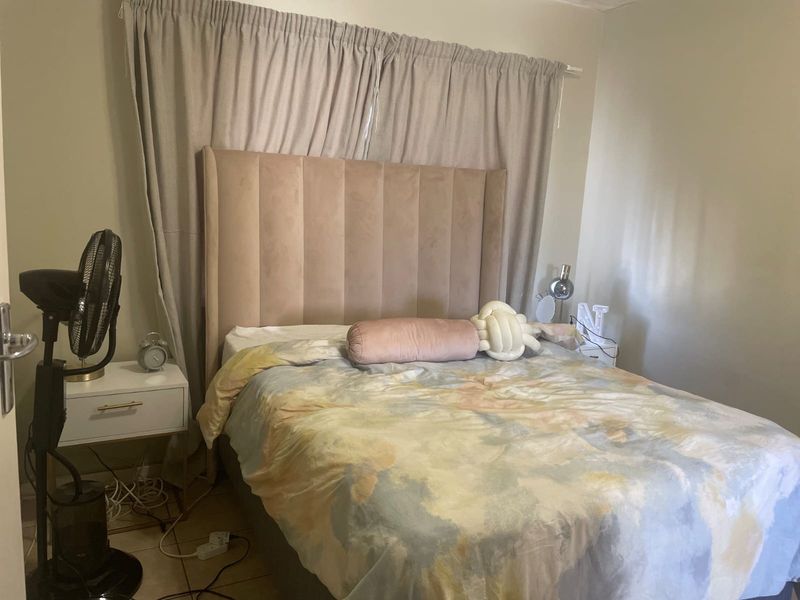 A standard bedroom featuring tiled flooring and neutral wall finishes, providing a functional space for rest.