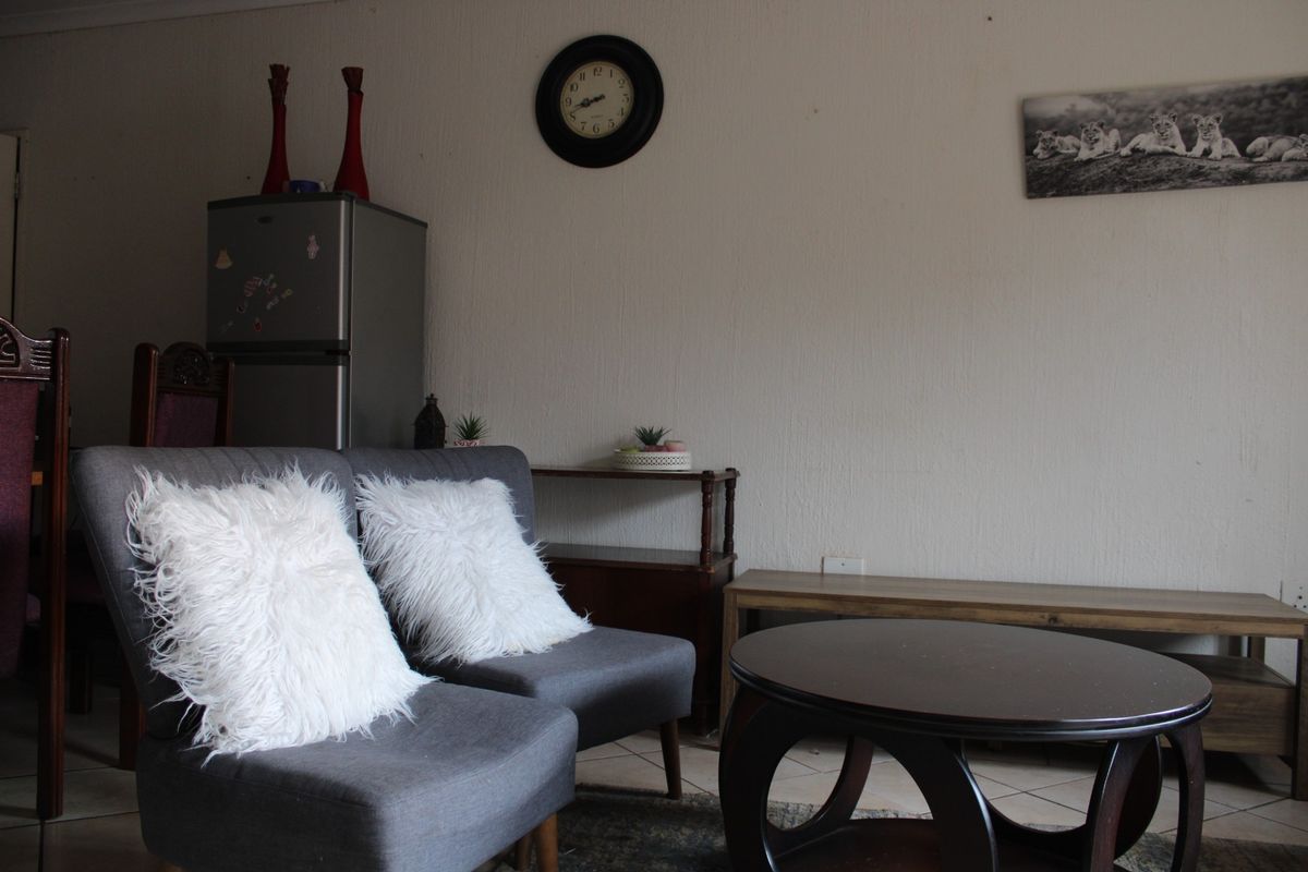 A living room area featuring tiled flooring and neutral wall finishes, providing a functional space for relaxation.