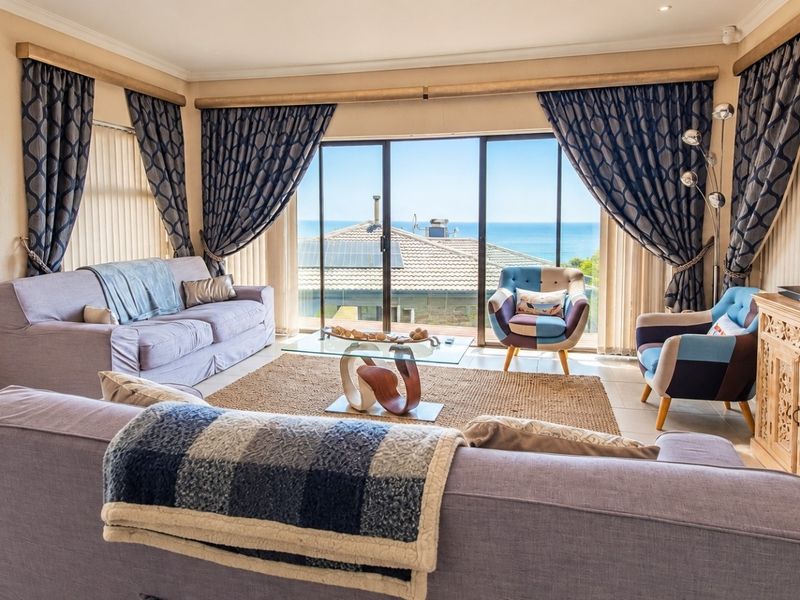 Spacious living room featuring large sliding glass doors that provide abundant natural light and expansive ocean views.