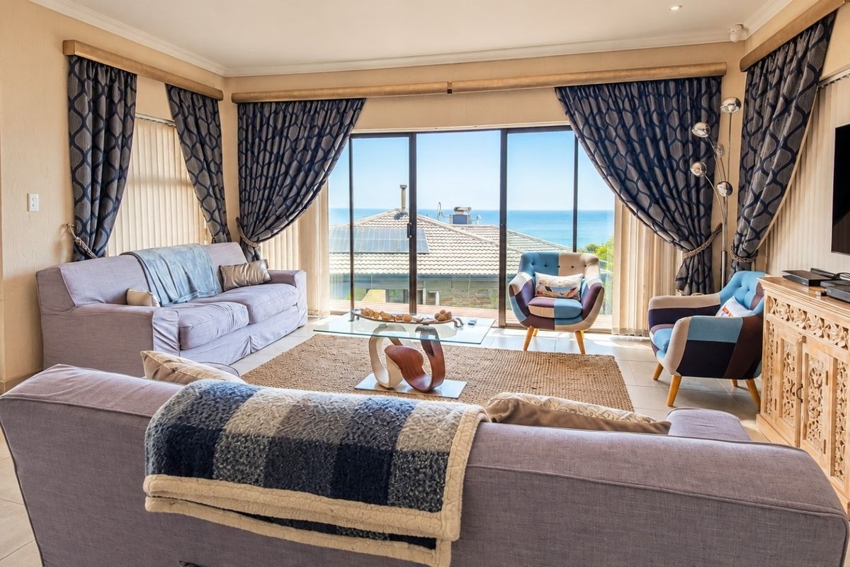 Spacious living room featuring large sliding glass doors that provide abundant natural light and expansive ocean views.