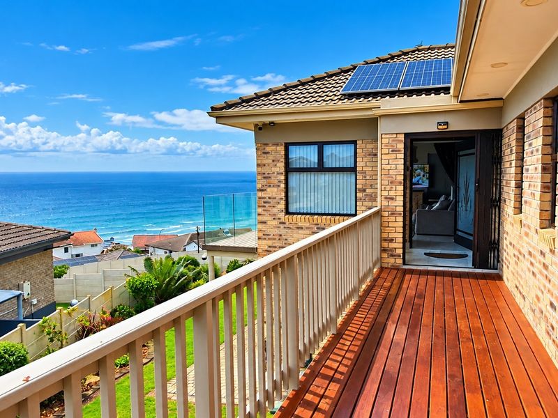 A well-maintained timber balcony featuring a glass balustrade, brick exterior, and solar panels, offering expansive ocean views.